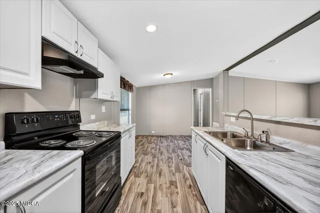 a kitchen with stainless steel appliances a sink stove and cabinets