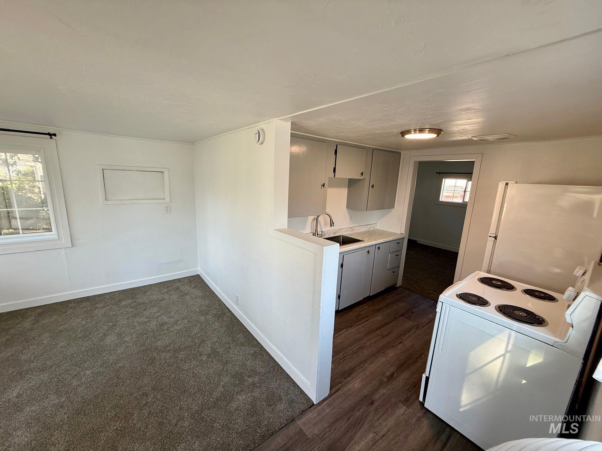 517 12th Street Clarkston, WA 99403 - Photo 12 of 16 Kitchen with white appliances, light countertops, dark carpet, and dark wood-style flooring