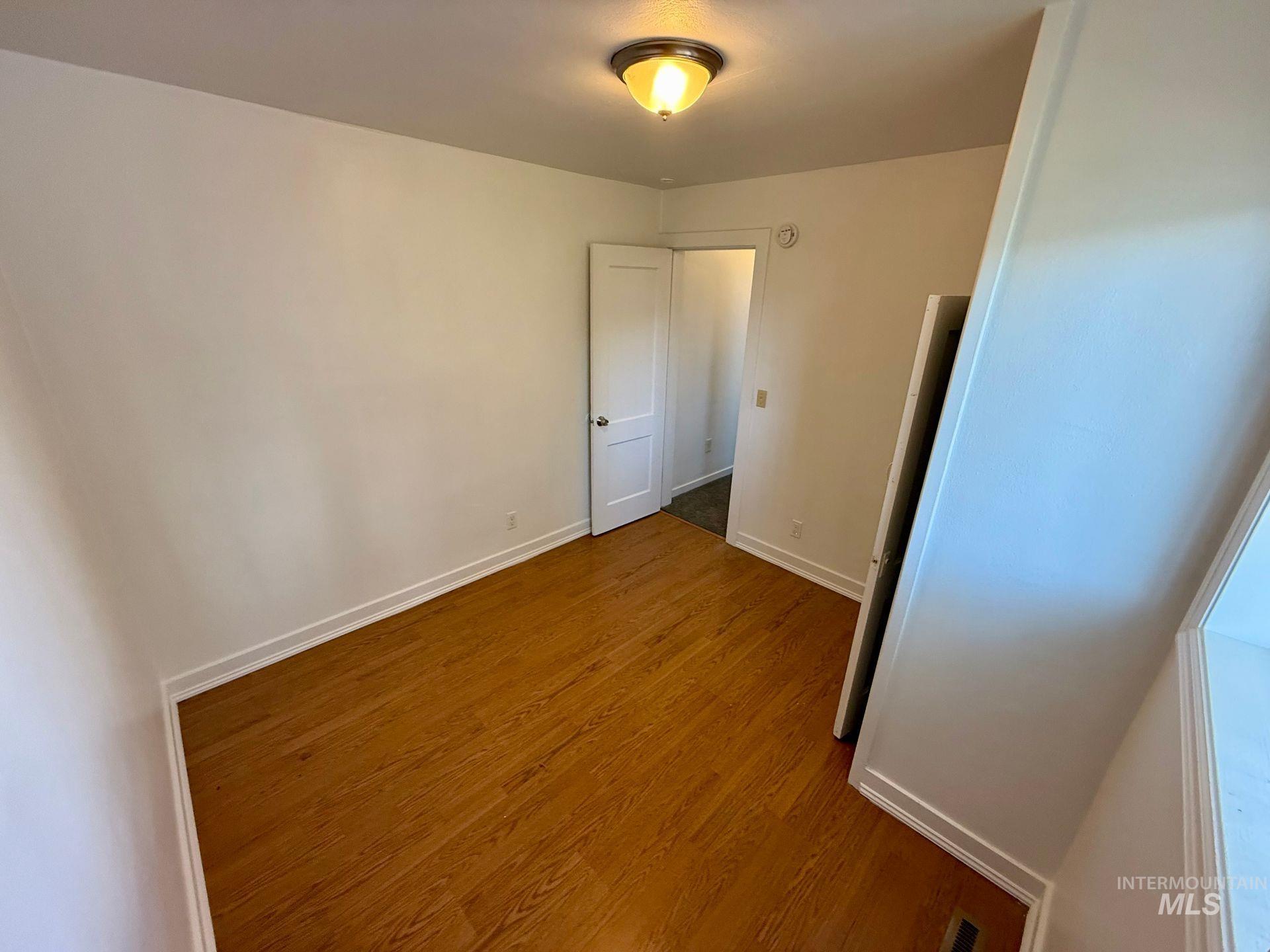 517 12th Street Clarkston, WA 99403 - Photo 2 of 16 Unfurnished bedroom featuring baseboards and dark wood finished floors