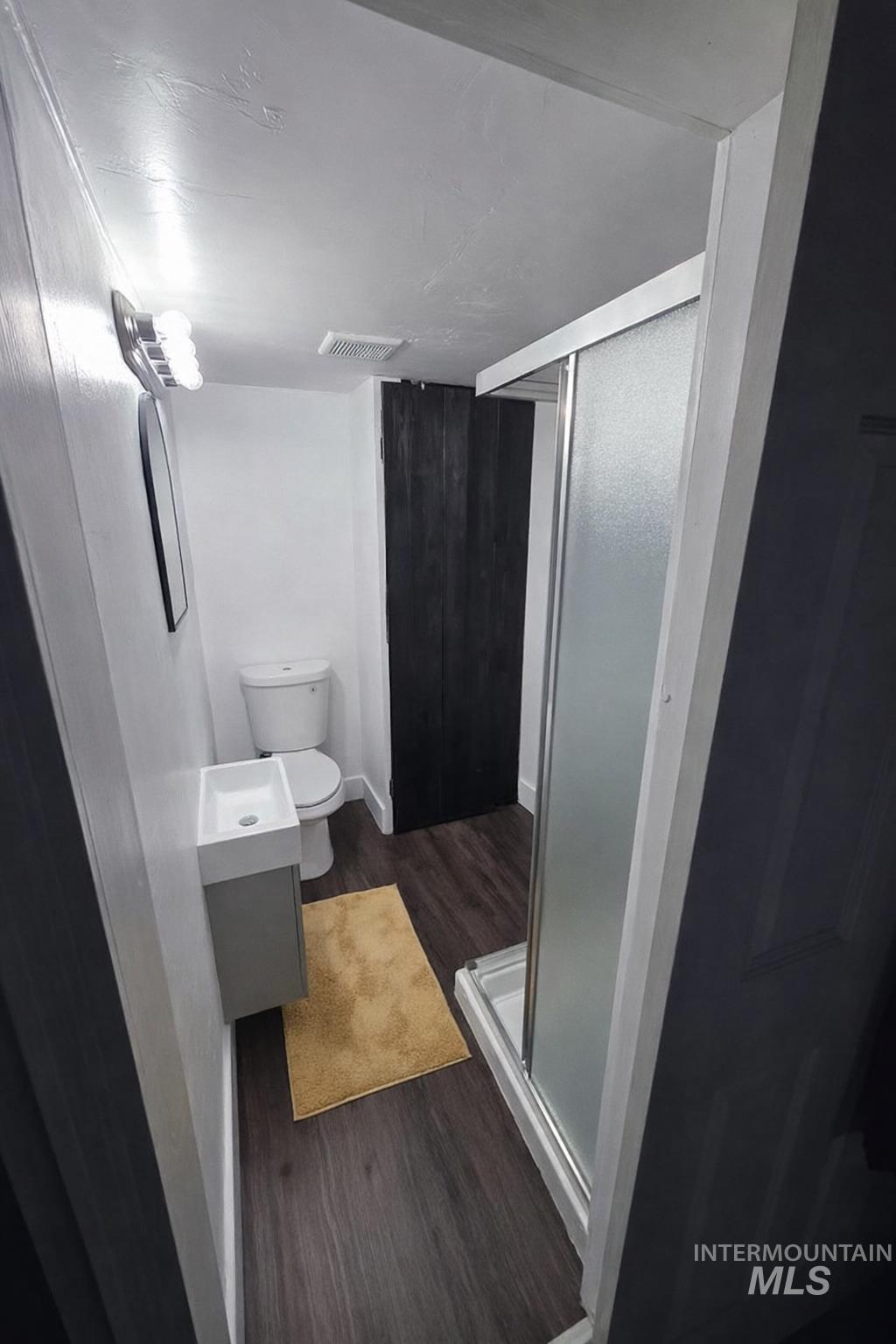 517 12th Street Clarkston, WA 99403 - Photo 9 of 16 Bathroom with a shower stall, vanity, and dark wood finished floors
