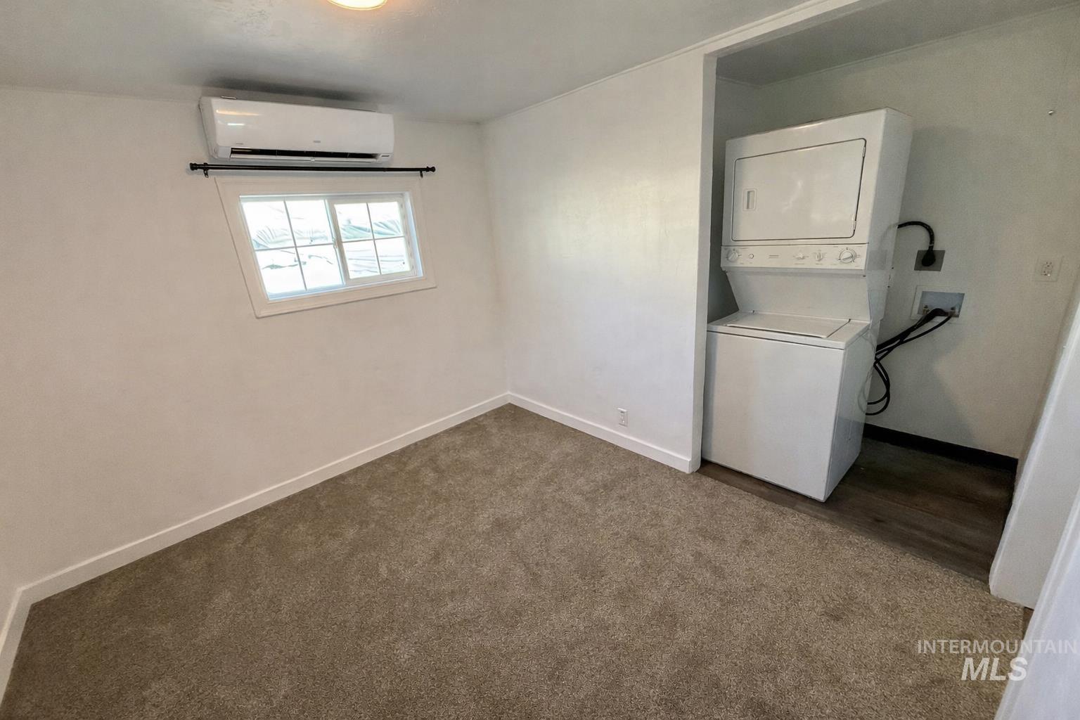 517 12th Street Clarkston, WA 99403 - Photo 10 of 16 Laundry area featuring dark colored carpet, a mini split for heating / cooling, and stacked washer and dryer