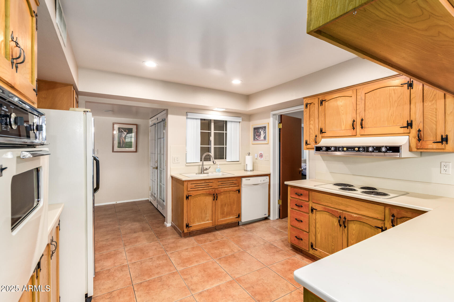 6419 East Cactus Road Scottsdale, AZ 85254 - Photo 11 of 38 a kitchen with stainless steel appliances granite countertop a stove a sink dishwasher and a refrigerator