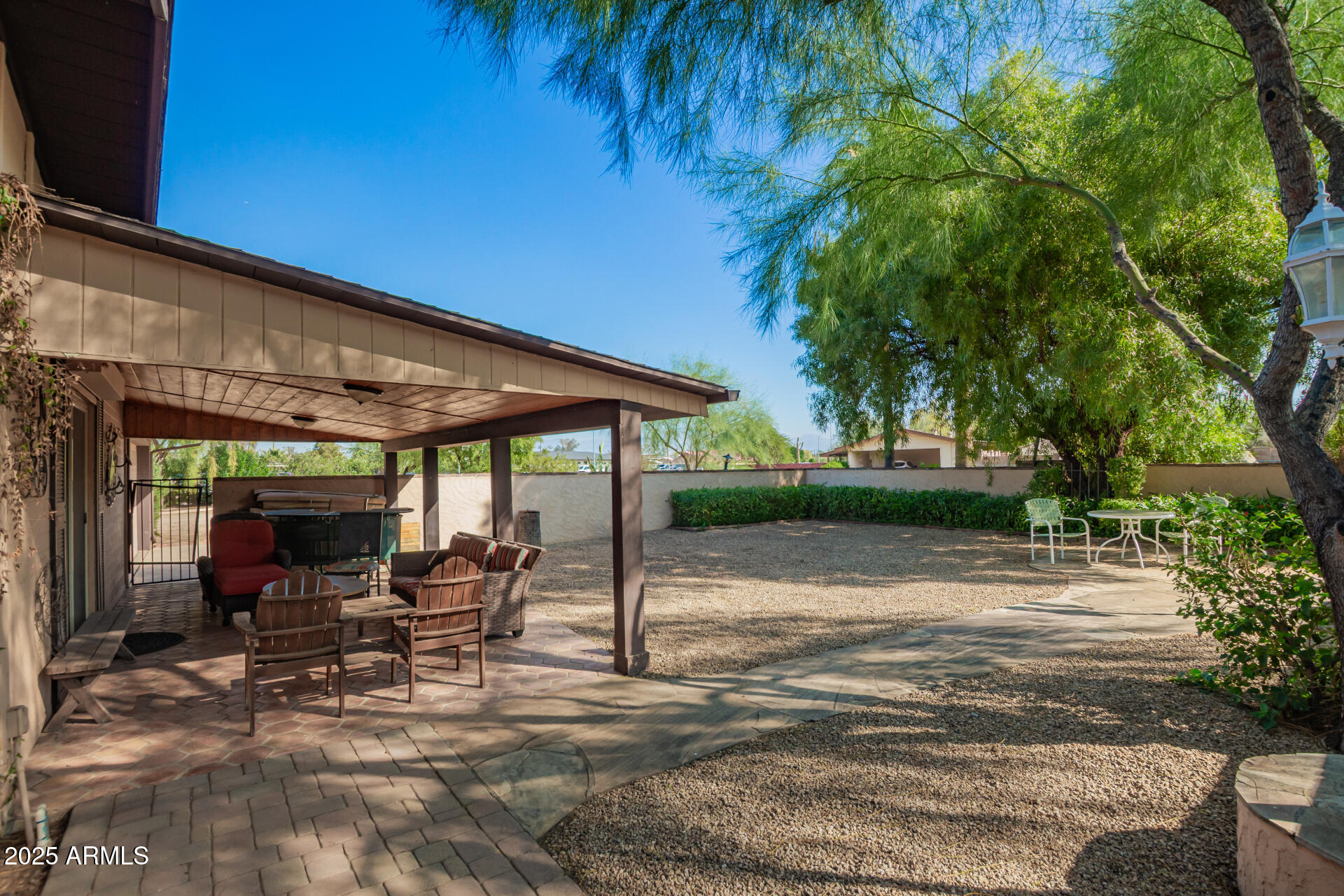 6419 East Cactus Road Scottsdale, AZ 85254 - Photo 31 of 38 a view of a patio with table and chairs under an umbrella with large trees