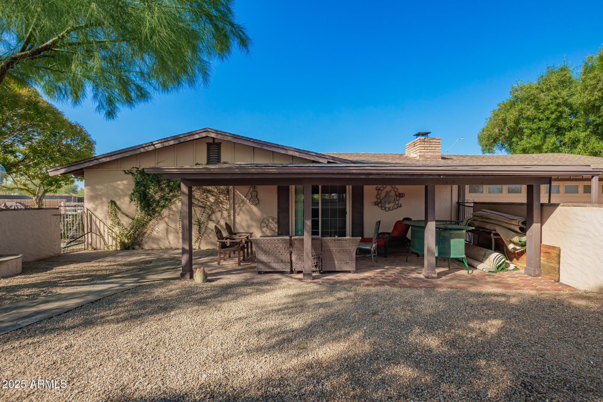 6419 East Cactus Road Scottsdale, AZ 85254 - Photo 34 of 38 a view of a house with large trees and wooden fence