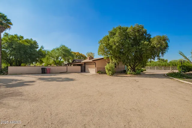 a view of a house with a yard and large tree