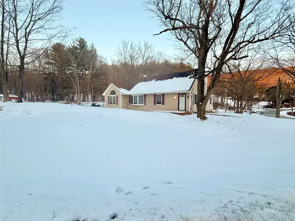 a view of a house with a yard covered in snow