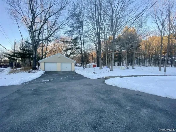 a view of white house with a yard covered with snow