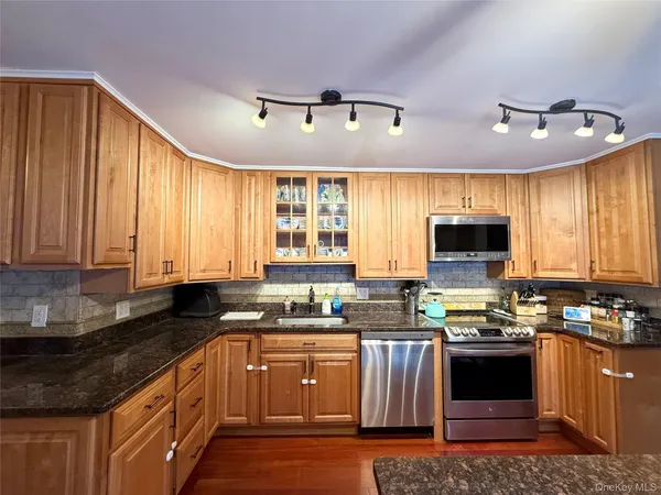 a kitchen with granite countertop a stove sink and microwave