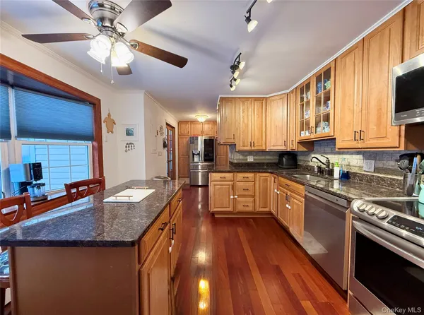 a kitchen with granite countertop wooden cabinets a stove top oven a granite counter space and a sink