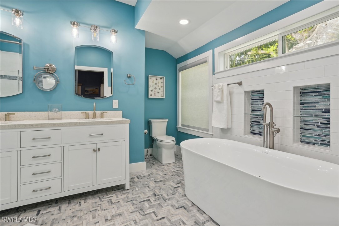 8335 Main Street Bokeelia, FL 33922 - Photo 32 of 47 a spacious bathroom with a double vanity sink and a mirror