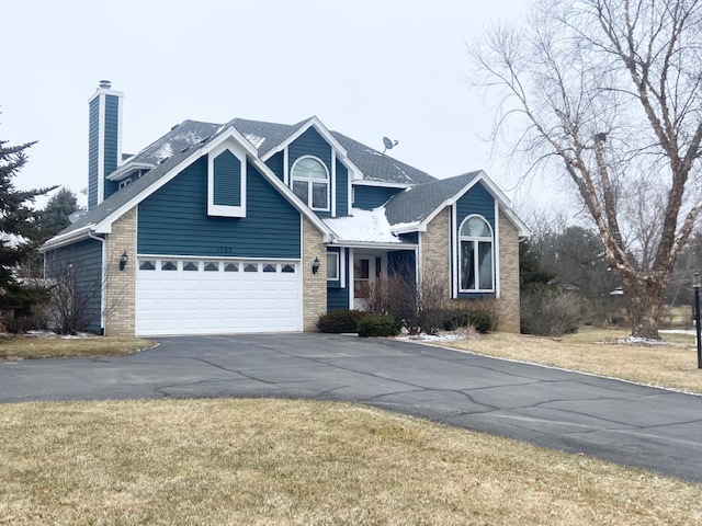 1702 Elm Street Spring Grove, IL 60081 - Photo 28 of 30 a front view of a house with a yard and garage