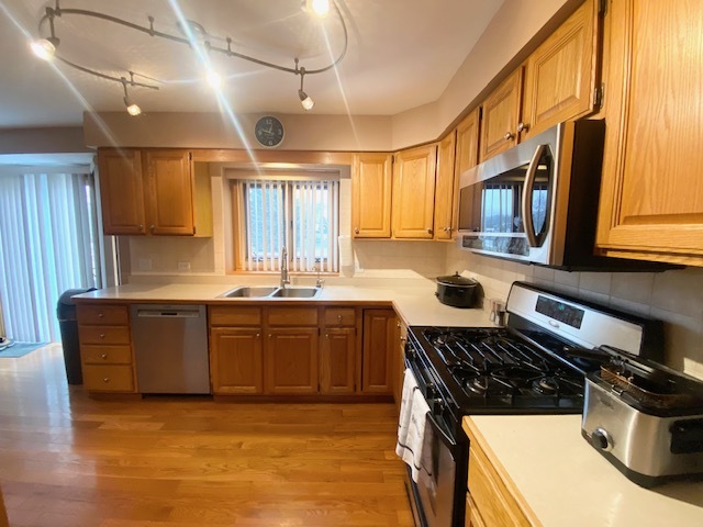 1702 Elm Street Spring Grove, IL 60081 - Photo 7 of 30 a kitchen with stainless steel appliances granite countertop a stove a sink and a microwave