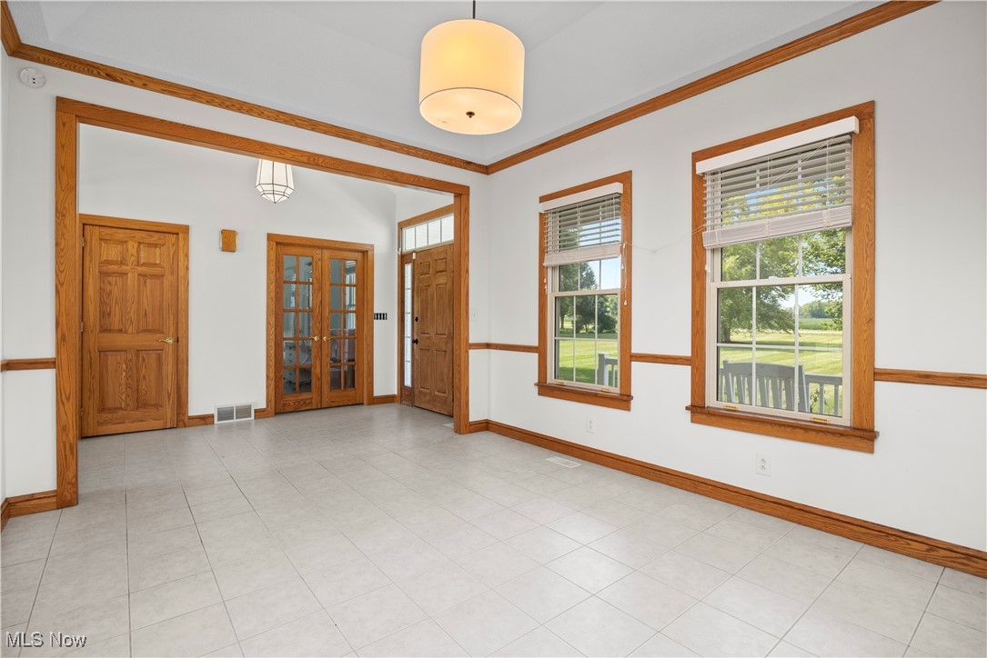 5310 Billings Road Castalia, OH 44824 - Photo 18 of 50 Unfurnished room with french doors, ornamental molding, plenty of natural light, and light tile patterned flooring
