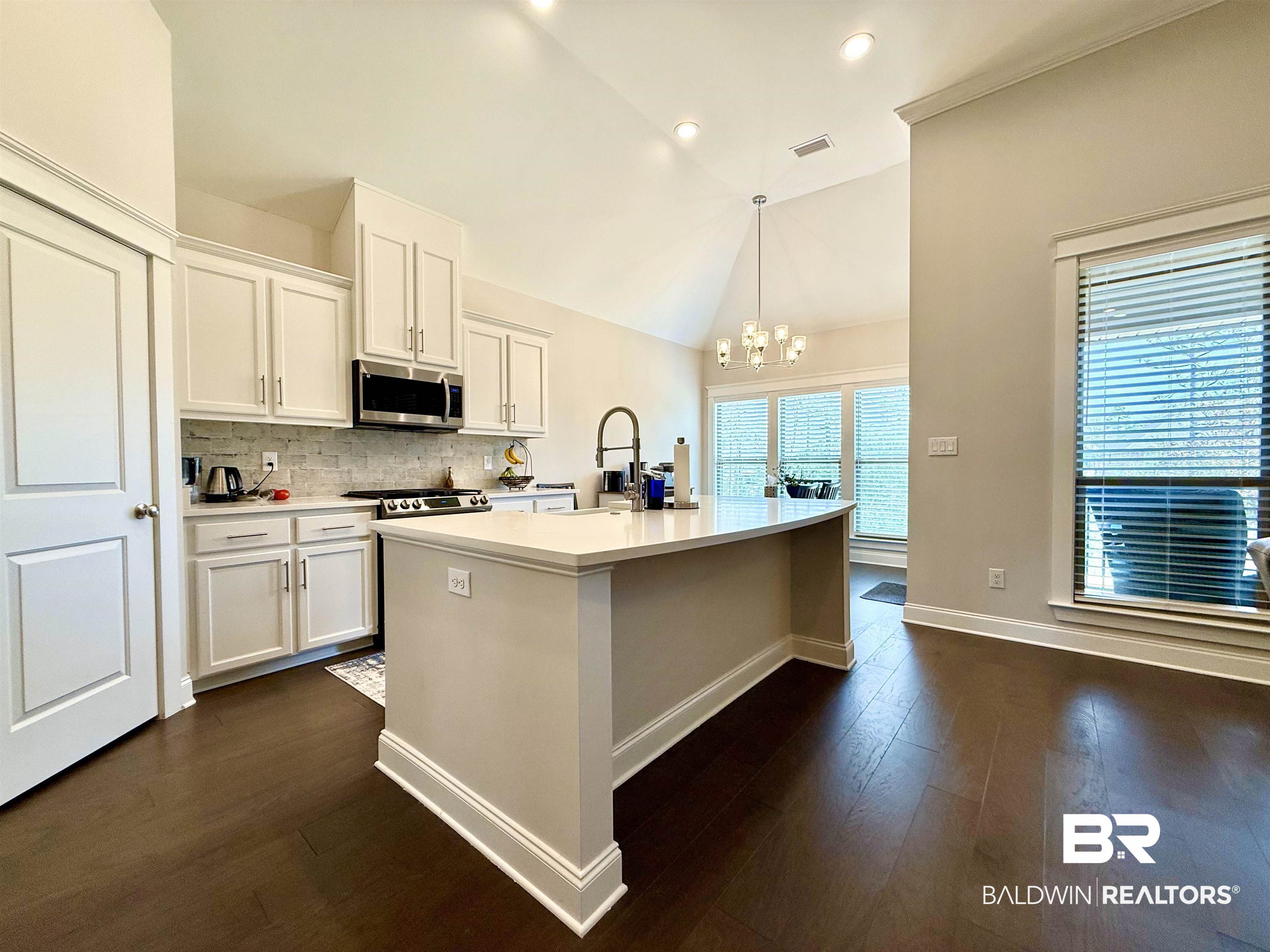 31748 Canopy Loop Spanish Fort, AL 36527 - Photo 13 of 22 Kitchen with a center island with sink, pendant lighting, white cabinets, and lofted ceiling