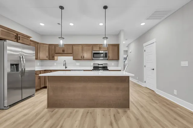 a kitchen with kitchen island a sink stainless steel appliances and cabinets
