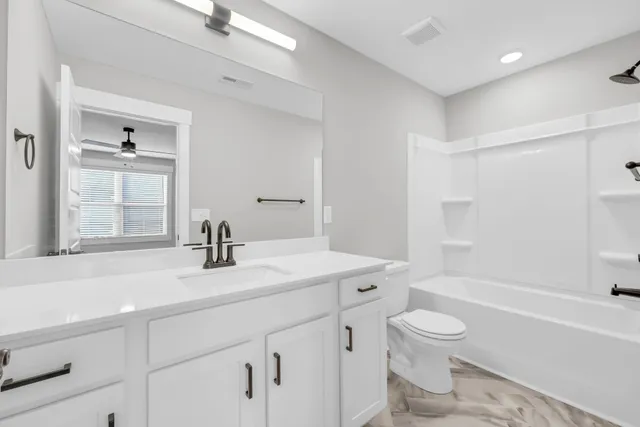 an empty room with a window and a ceiling fan