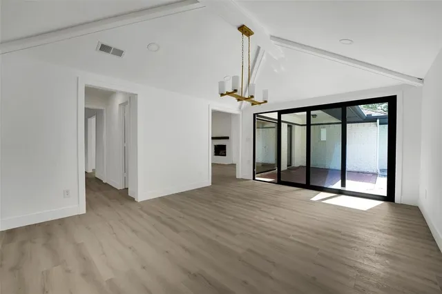 a view of an empty room with glass door and a window