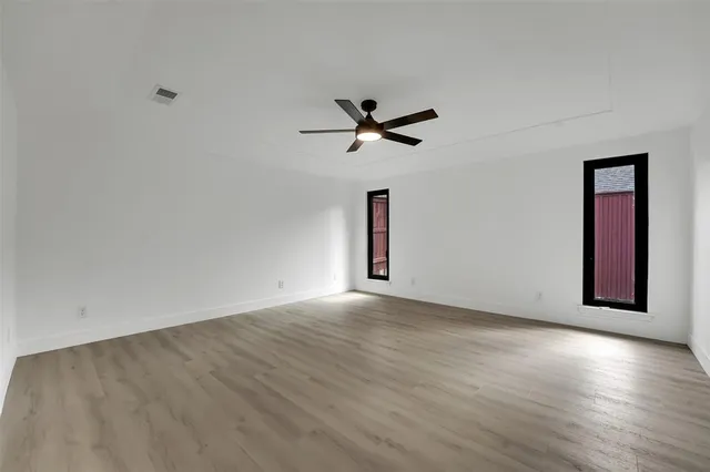 a view of a room with wooden floor and a ceiling fan