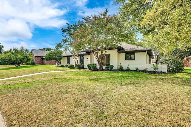 a front view of house with yard and trees in background