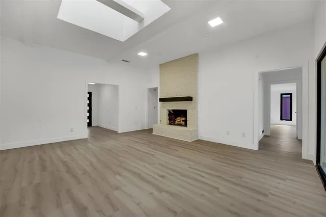 an empty room with wooden floor and fireplace