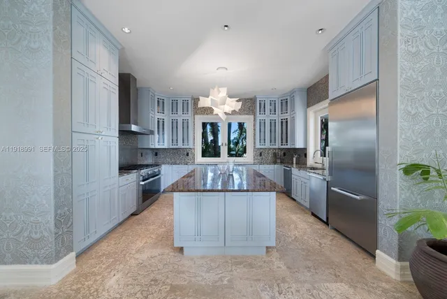 a kitchen with kitchen island a counter top space a sink stainless steel appliances and cabinets