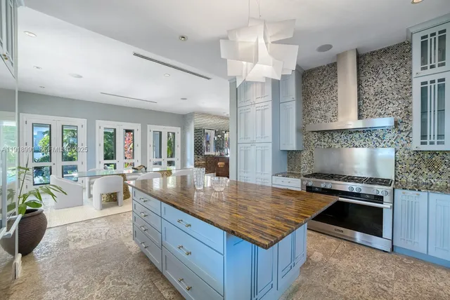 a large kitchen with kitchen island a stove a sink a counter space and living room view