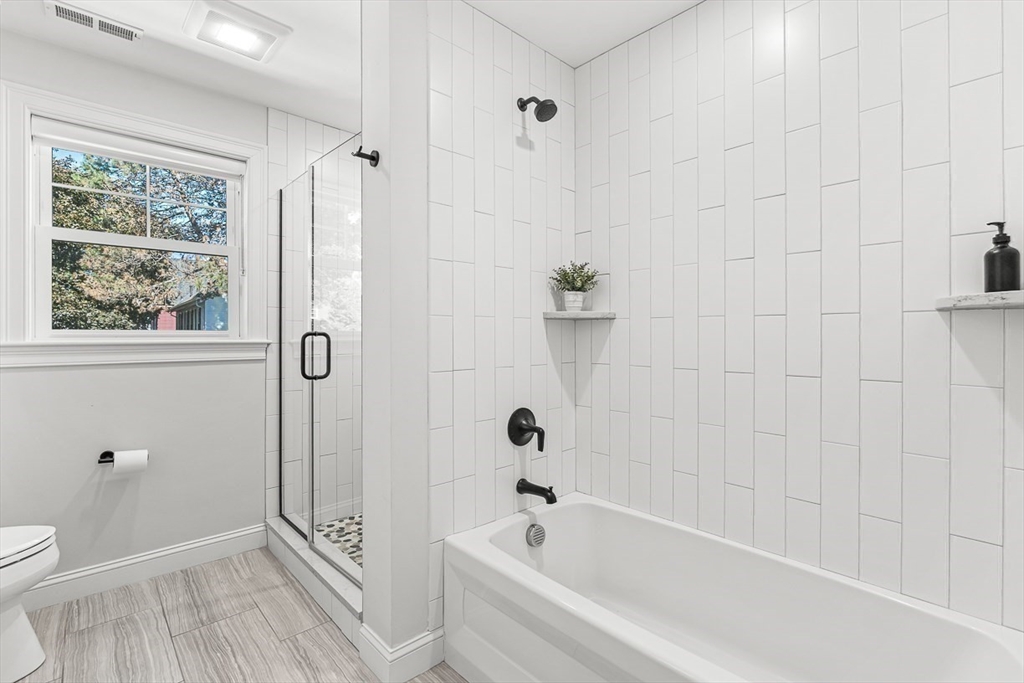 237 Swanton Street Winchester, MA 01890 - Photo 19 of 34 a bathroom with a bathtub a window and a shower