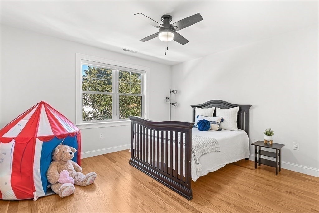 237 Swanton Street Winchester, MA 01890 - Photo 22 of 34 a bedroom with a bed and a chandelier