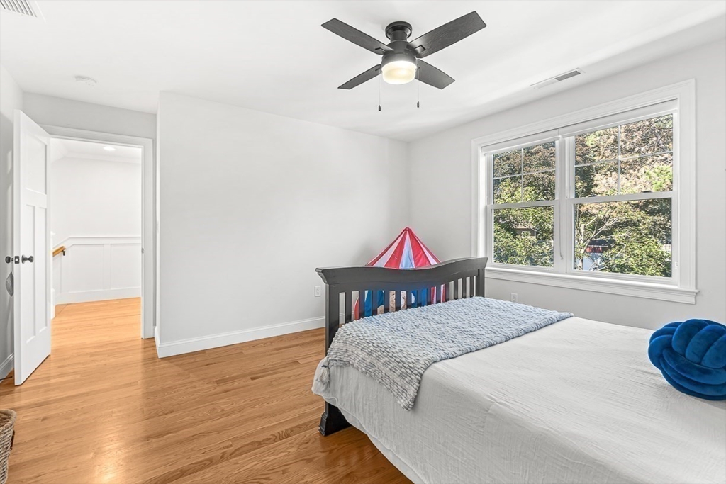 237 Swanton Street Winchester, MA 01890 - Photo 23 of 34 a bedroom with a bed and a chandelier