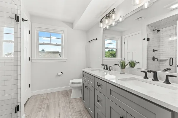 a bathroom with a sink a toilet and a mirror