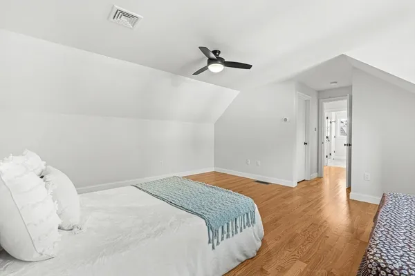 a bedroom with a bed and wooden floor