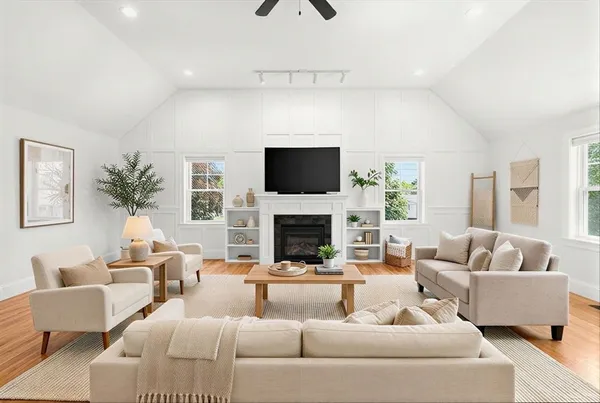 a living room with furniture a fireplace and a flat screen tv