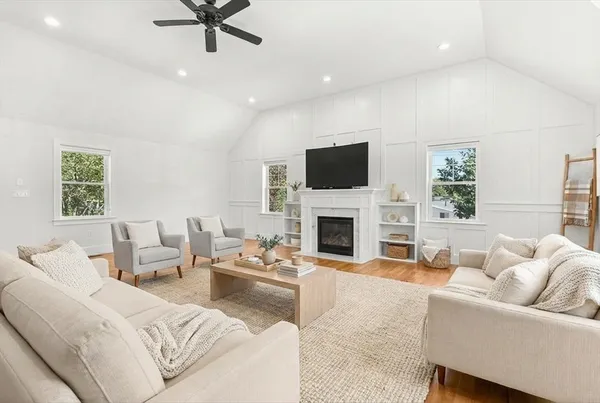 a living room with furniture a fireplace and a flat screen tv