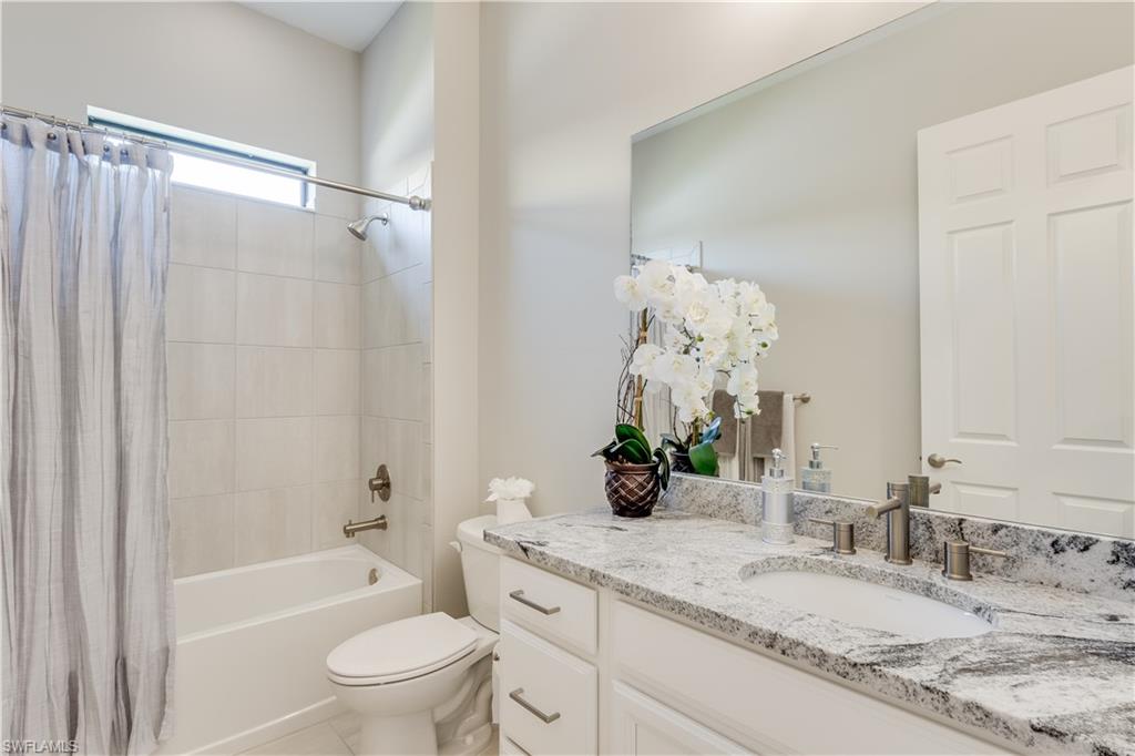 1423 Mockingbird Drive Naples, FL 34120 - Photo 17 of 26 a bathroom with a granite countertop sink a toilet and shower