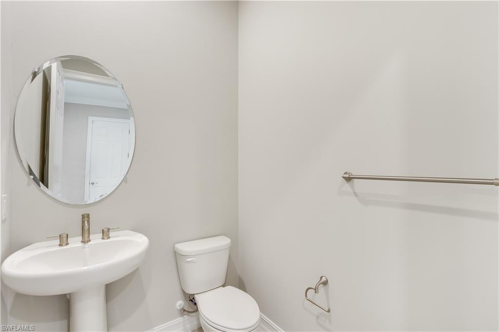1423 Mockingbird Drive Naples, FL 34120 - Photo 23 of 26 a bathroom with a toilet sink and mirror