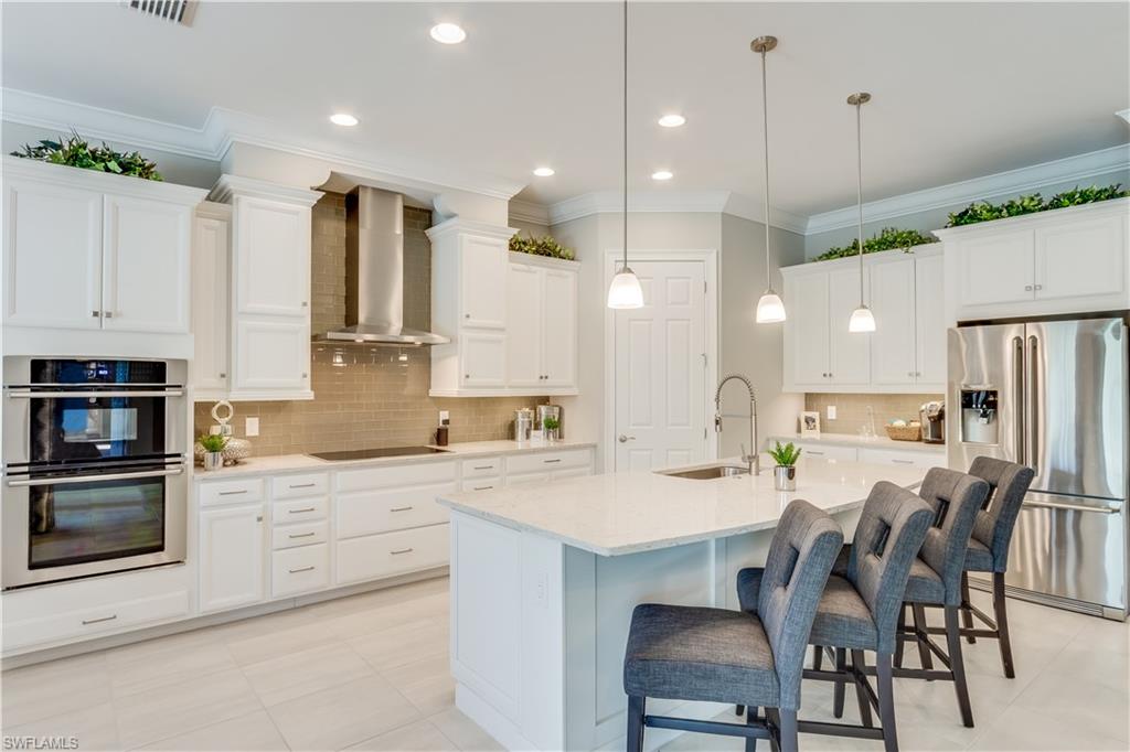 1423 Mockingbird Drive Naples, FL 34120 - Photo 8 of 26 a large kitchen with a table and chairs in it