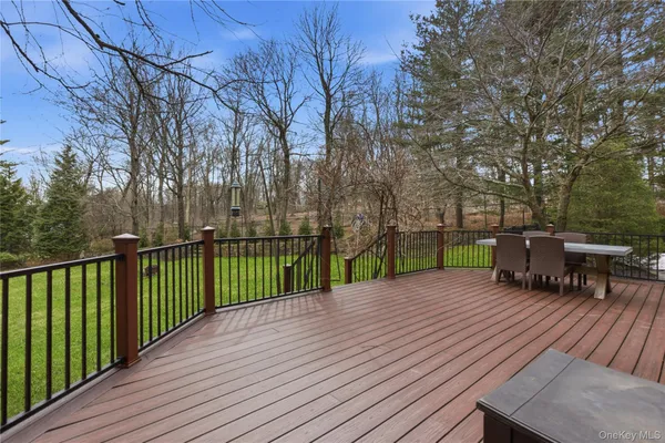 a view of a deck with a table and chairs next to a yard