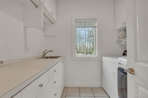 a utility room with cabinets washer and dryer