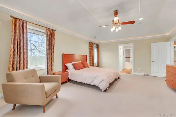 a spacious bedroom with a bed couch and windows