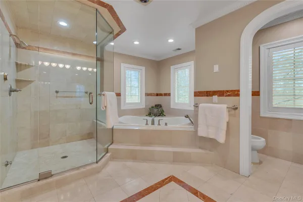 a spacious bathroom with a glass shower door and a bathtub
