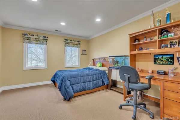 a bedroom with a workspace and a window