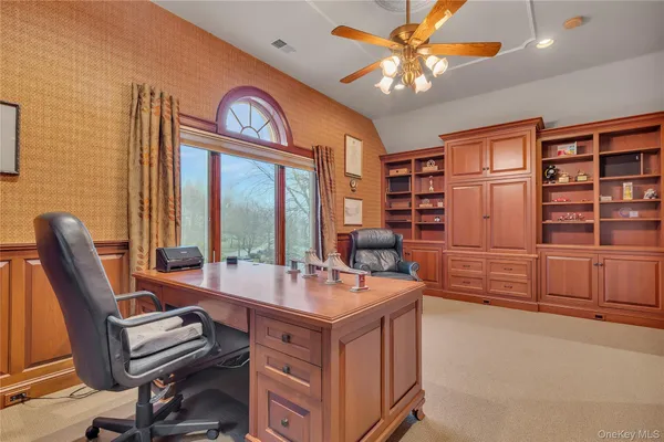 a view of a workspace with furniture and a window