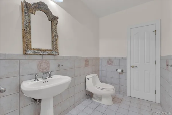 a bathroom with a toilet sink and mirror