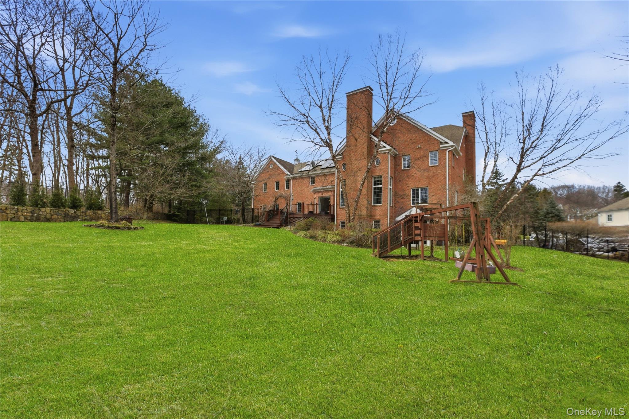199 Hirst Road Briarcliff Manor, NY 10510 - Photo 46 of 50 View of the back of 199 Hirst Road and the .92 acre level rear lawn area and Trex Deck in the fenced/stone- bordered backyard.