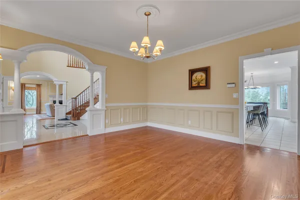 a view of a livingroom with wooden floor staircase and a kitchen