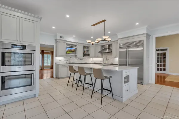a kitchen with kitchen island granite countertop a sink cabinets and stainless steel appliances