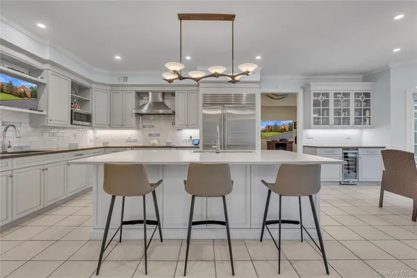 a kitchen with granite countertop a counter space chairs cabinets and appliances