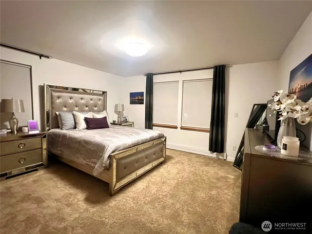 a bedroom with a bed and a mirror on the dresser