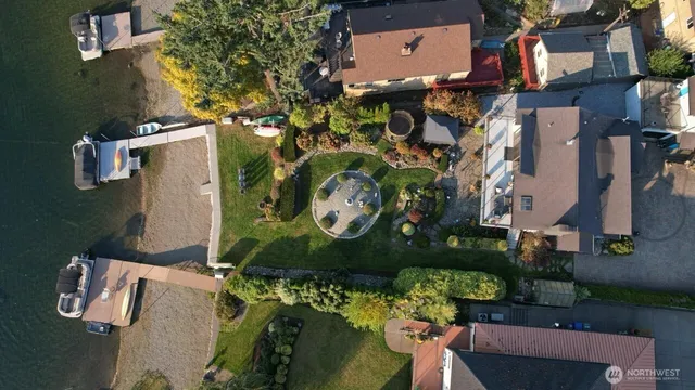 an aerial view of a house with a yard and a large tree