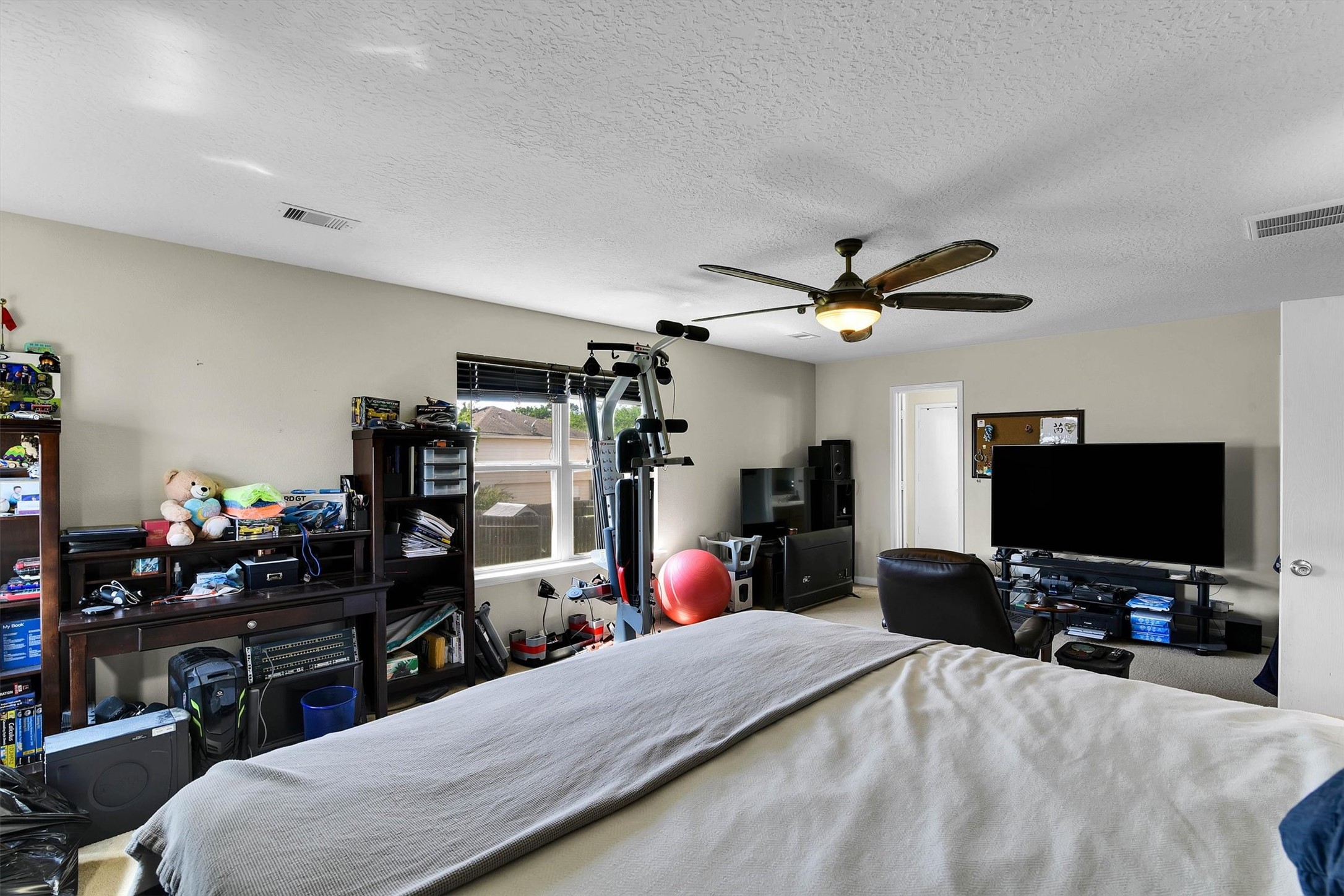3003 Legends York Drive Spring, TX 77386 - Photo 19 of 29 a bedroom with a bed and a flat tv screen on dresser